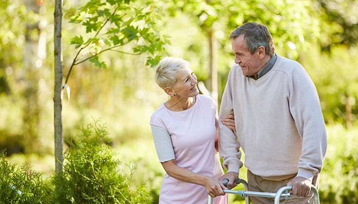woman walking with a man and a walker